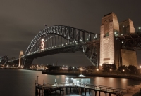 Sydney Harbour Bridge mit Jefferson Street Wharf im Vordergrund. Zur Zeit der Aufnahme fand in Sydney das APEC-Leader treffen statt. Daher die Leuchtreklame auf der Bridge.